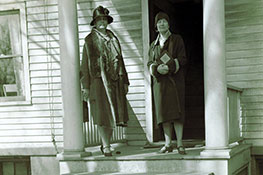 Archival photo of women standing on the porch. Link to Life Stage Gift Planner Over Age 70 Gifts.